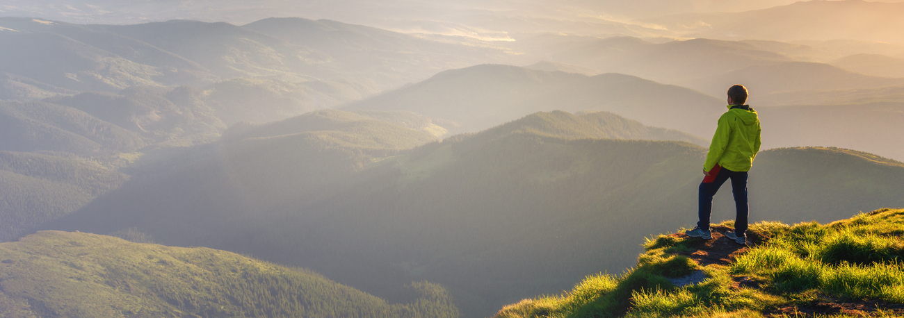 Person gazing out on a mountain range